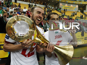Kairat's forward Alexandre Moraes and  (L) and Barcelona's forward Esteban Cejudo (R)  pose with their trophy after winning the UEFA Futsal...