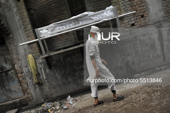 An Indian muslim man walks past the dead body of Bhure Ali during his funeral in Mustafabad area of east Delhi, India on 04 March 2020. Ali,...