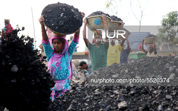 Bangladeshi laborers unload coal from boats  ahead of International Women's Day at the River Turag in Dhaka, Bangladesh, on March 7, 2020. 