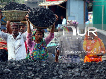 Bangladeshi laborers unload coal from boats  ahead of International Women's Day at the River Turag in Dhaka, Bangladesh, on March 7, 2020. (