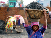 Bangladeshi laborers unload coal from boats  ahead of International Women's Day at the River Turag in Dhaka, Bangladesh, on March 7, 2020. (