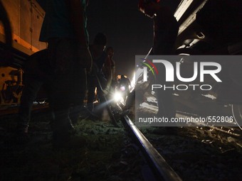 Makati, Philippines - Railway men work on the railroad tracks after a Philippine National Railway (PNR) Train derailed in Makati city, south...