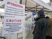 An epidemic prevention staff member checks a person's body temperature for the Coronavus Emergency at the port of Naples, Italy March 09, 20...
