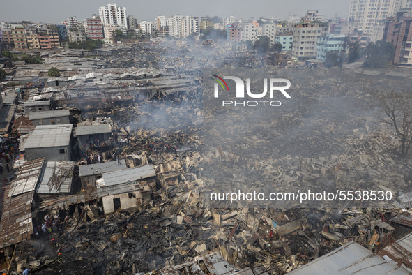 Firefighters with the help of locals work to douse a fire in a slum in Mirpur, Dhaka, Bangladesh. on March 11, 2020. More than 1,000 shantie...