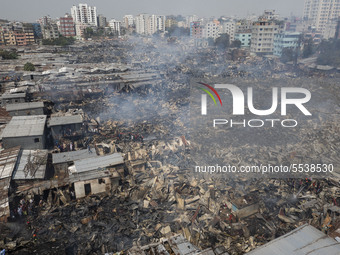 Firefighters with the help of locals work to douse a fire in a slum in Mirpur, Dhaka, Bangladesh. on March 11, 2020. More than 1,000 shantie...