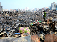 Bangladeshi Slum-dwellers have seen searching for their household belongings after a devastating fire that broke out at Rupnagar slum on Mar...