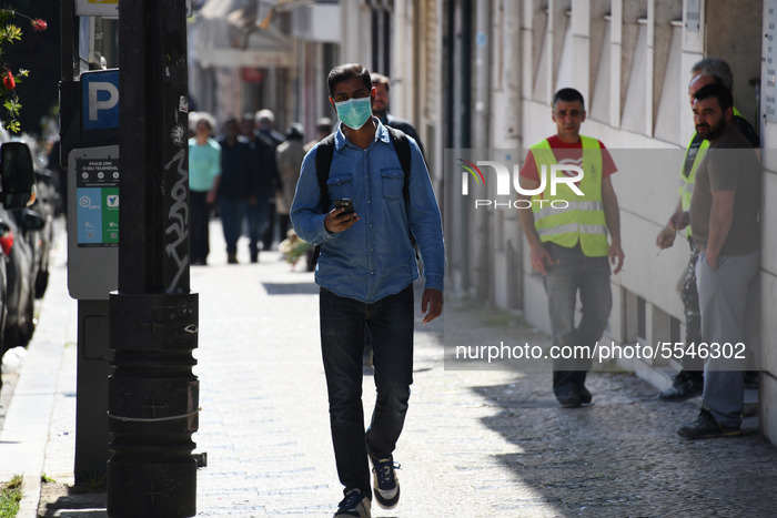 Tourists wear protective masks against a possible coronavirus infection in the city of Lisbon, Portugal on March 14, 2020. The Government is...