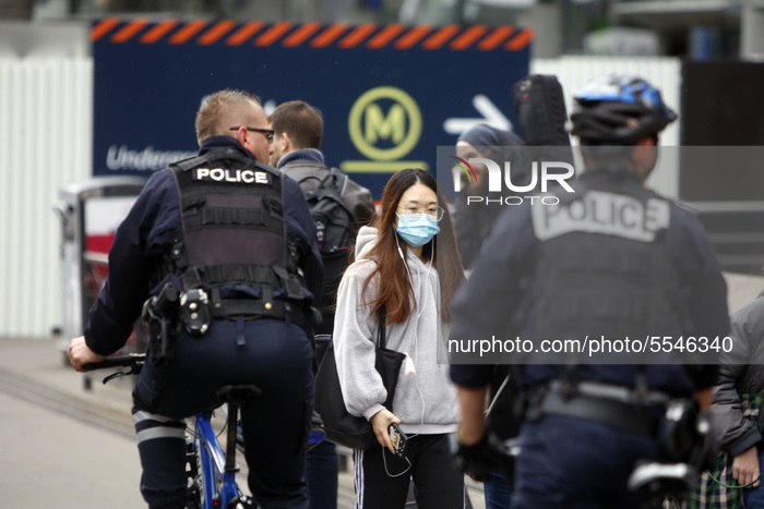 Woman wearing a protective mask seen walking in front the Montparnasse metro station in Paris, France on March 14, 2020. RATP and SNCF has a...