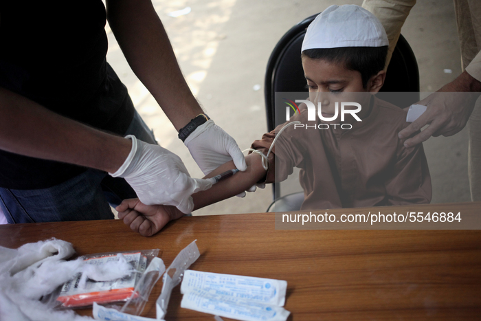 A medical specialist collects blood sample of a child at a temporary medical camp ( Especially made for Fever, cold , Headache and Dyspnoea...