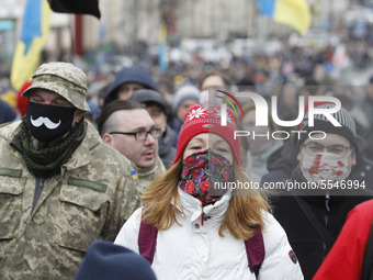 People wearing protective masks participate at a rally called 'March of Patriots' at the Volunteer Day in honor of volonteer fighters who jo...