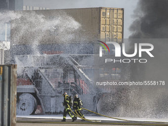 Firemen try to extinguish flames at the autonomous port of Strasbourg, France, on March 18, 2020.  (