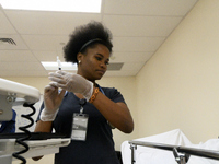 Student nurse Nazarine Beweh attends to a patient care manakin in a training simulation at an education lab of the License Practical Nursing...
