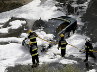 Firefighters try to extinguish a fire in a car in Cascais, Portugal, on March 26, 2020. (