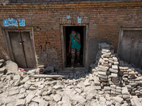 A woman is leaving from her damaged house where rubbles are everywhere around in the small village of Sankhu outside Kathmandu. 
Nepalese ea...