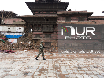 A soldier from the Nepal Army walks past buildings damaged by the 2015 Nepal earthquake, Kathmandu Durbar Square, Kathmandu, Nepal. An earth...