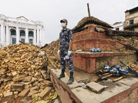 A policeman from the Nepal Police Force stands guard over fallen rubble following the 2015 Nepal earthquake, Kathmandu Durbar Square, Kathma...