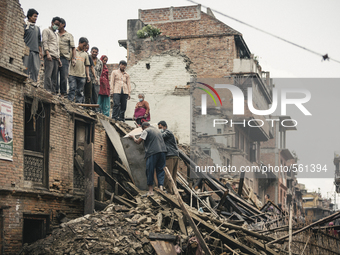A group of survivors stand on top of a building damaged by the 2015 earthquake in Nepal. Despite many search and rescue teams arriving from...