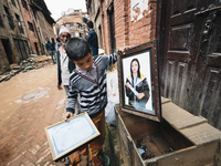 A boy places family possessions in a wooden box as his family prepare to leave their damaged home., Durbar Square, Bhaktapur, Nepal - Photo:...