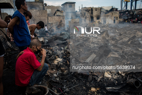 A man weeps as he looks at the debris of his house destroyed after a fire broke out in a slum area in Tondo, Manila in the Philippines on Ap...