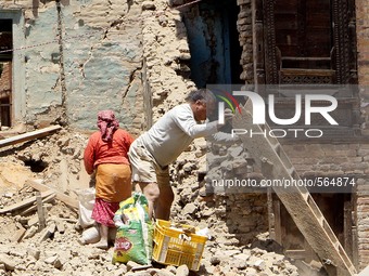 MAY 4, 2015, LALITPUR, NEPAL : Locals collects their belongings from the debris of a destroyed house at Bungamati in Lalitpur, May 4, 2015,...