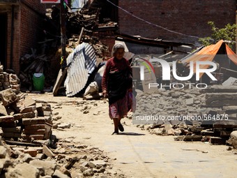 MAY 4, 2015, LALITPUR, NEPAL : A woman walks past the debris of a destroyed temple at Bungamati in Lalitpur, May 4, 2015, after the devastat...
