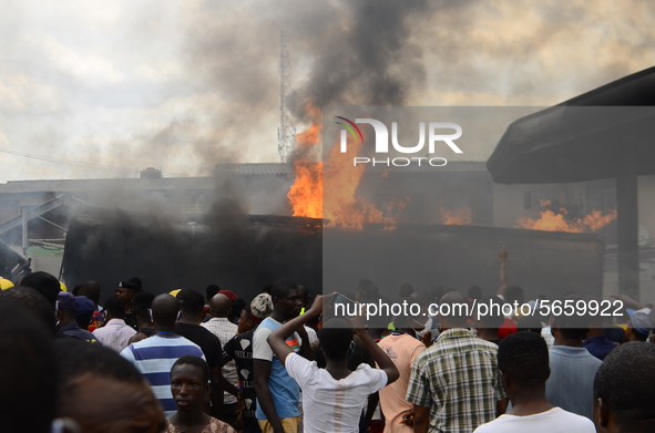 Crowds gather at the scene of the fire outbreak ignoring the social distancing rules, at the Nigerian National Petroleum Corporation (NNPC)...