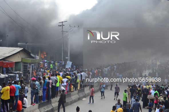 Crowds gather at the scene of the fire outbreak ignoring the social distancing rules, at the Nigerian National Petroleum Corporation (NNPC)...