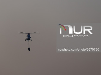 A firefighting helicopter carries out an operation to extinguish a forest fire in Goseong, some 160 kilometers northeast of Seoul, on May 2,...