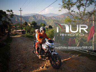 Rama is taking her old mother to the hospital out of the village on motorbike. Dhading, Nepal. May 5, 2015 (