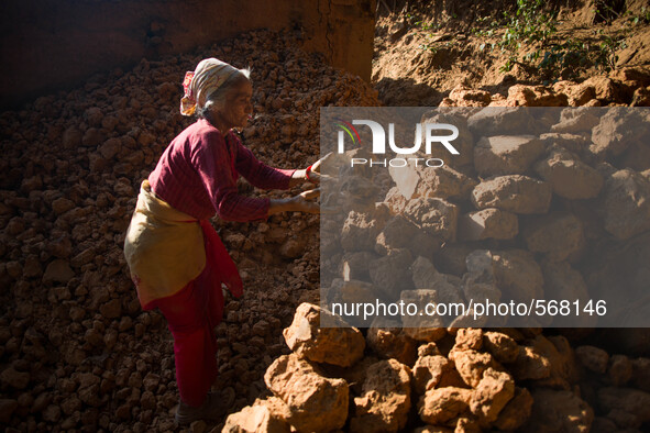 An old woman is clearing rubbles. Dhading, Nepal. May 5, 2015 