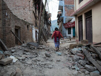 A woman pass through the devastated village of Khokana, south of Kathmandu.
The death toll has risen to more than 7000 people and more than...