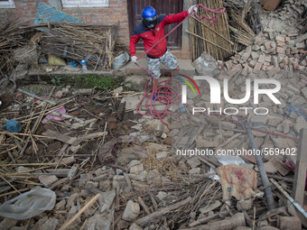 Volunteer holds a rope as he gonna help the Nepalese Army to remove the rubbles from the collapsed building in the Khokana Village, south of...