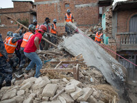 Nepalese Army helps by volunteers are pushing this large piece of rubble in order to clean the area in the Khokana Village, south of Kathman...