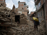 A man is carrying a big rice bag as he pass through the rubbles from collapsed houses in the Khokana Village, south of Kathmandu.
The death...