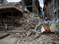 A woman pass through the devastated village of Khokana, south of Kathmandu.
The death toll has risen to more than 7000 people and more than...