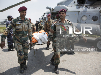 KATHAMNDU, NEPAL-- May 6, 2015--Military officials carry the bodies of 7 earthquake victims off a helicopter. The bodies were found by Spani...