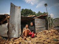 Shikha (left) and Sonu (right) are sitting infront of her destroyed house. Bandevi village, Kabrepalan Chowk, Nepal. May 6, 2015 (