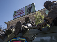 The men on the background of the poster with a greeting from the mayor of the Victory Day.
On the eve of the May holidays in Kharkov was st...