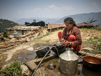 A woman is washing dishes in front of her destroyed house. Sindhupal Chowk, Nepal. May 7, 2015. (