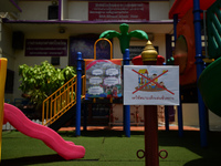 An empty playground with sign temporarily out of service in the school due coronavirus outbreak during the semester off at Wat Mahannapharam...
