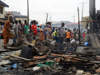 People gather remains of their belongings as fire razed a market called Olaleye Market in the area somolu area of Lagos State, on May, 30, 2...