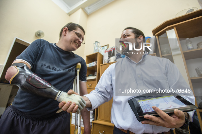 Stuzhenko Vasyl, who lost his arm and a leg during fighting near Illovaisk in the Donetsk region last August, shakes hand by his bionic hand...