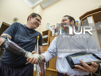 Stuzhenko Vasyl, who lost his arm and a leg during fighting near Illovaisk in the Donetsk region last August, shakes hand by his bionic hand...