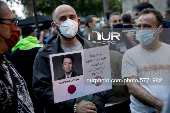 Nissan employees hold a photo of Nissan chief executive officer Makoto Uchida reading ''executioner'' during a protest against the closure o...