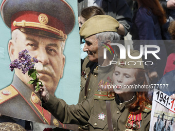 Communists stand with a portrait of Soviet dictator Josef Stalin during a ceremony to mark 70th anniversary of the end of WWII in front of t...