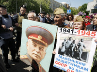 Communists walk with a portrait of Soviet dictator Josef Stalin during a ceremony to mark 70th anniversary of the end of WWII  near of the M...