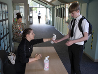   A teacher gives Year 10 pupils hand sanitizer. Ortu Gable Hall School in Corringham, Essex return after a long break due to the COVID-19 p...