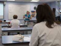  A teacher at the front of the class teaching a group of Year 10 pupils. Ortu Gable Hall School in Corringham, Essex return after a long br...