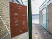   A COVID-19 poster on the door with footprints leading into the distance. Ortu Gable Hall School in Corringham, Essex return after a long b...