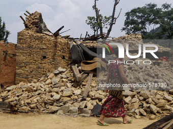 MAY 10, 2015, KATHMANDU, NEPAL -  Nepali people walk pass the debris of a destroyed house at Majuwa village, in Kathmandu, May 10, 2015, aft...